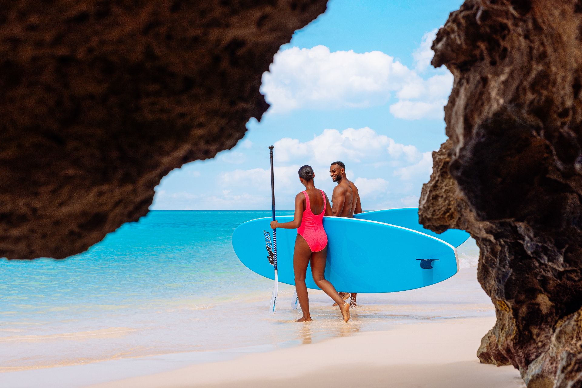 Couple paddleboarding through Bermuda's coastal caves